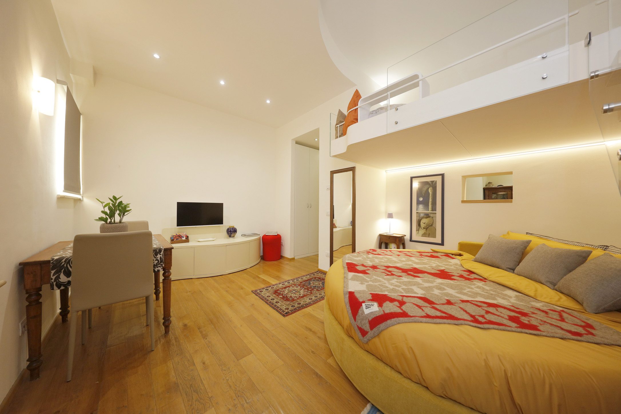 Zona living con scrivania sotto il soppalco dell'appartamento Cozy